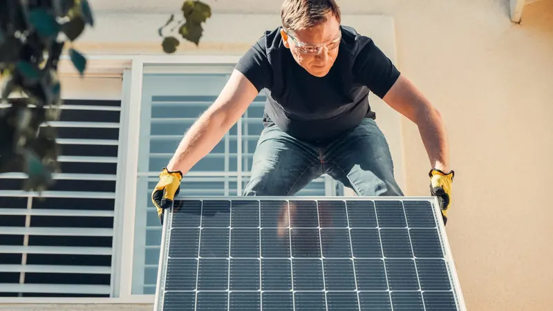 Installateur legt zonnepanelen op het dak
