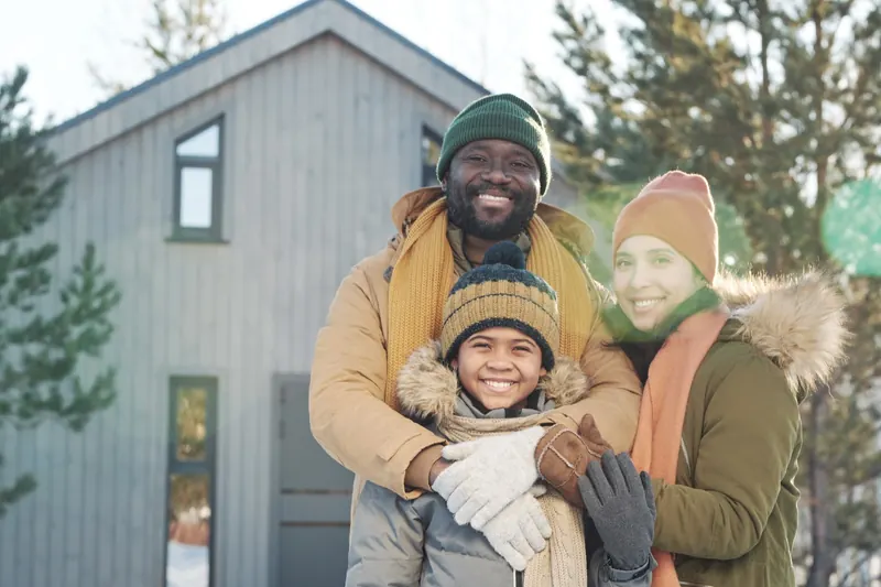 Gezin voor hun woning in de winter